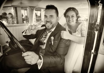 Novios conduciendo coche antiguo