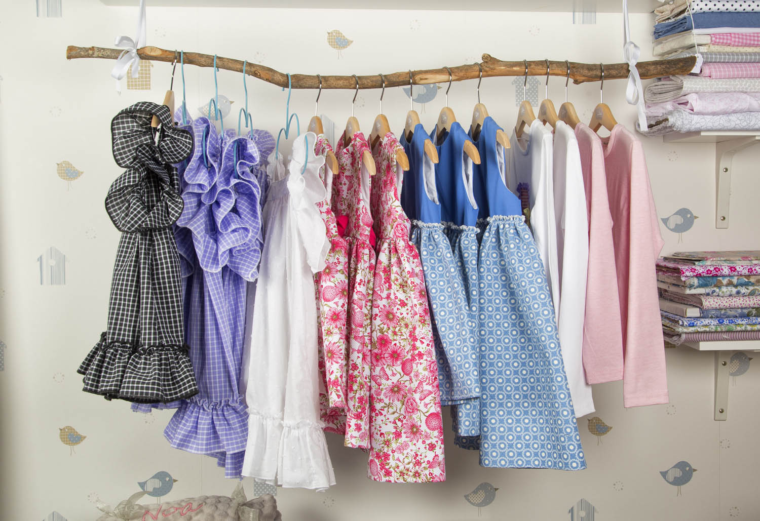 Ropa colgada en barra de madera