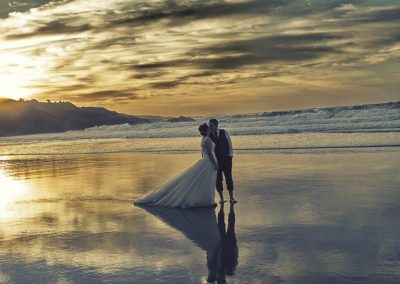 Playa en Atardecer con novios en postboda