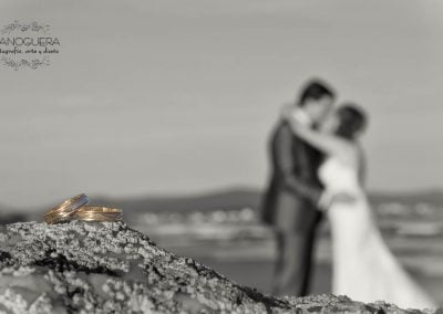 anillos de boda con novios de fondo