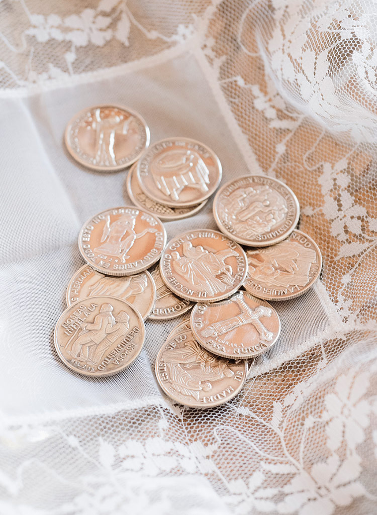 Monedas de arras de boda sobre paño blanco