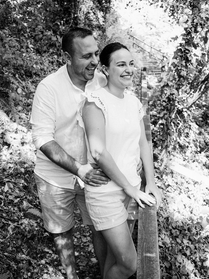 Pareja sonriente disfrutando de una sesión de fotos de preboda en un entorno natural en A Coruña